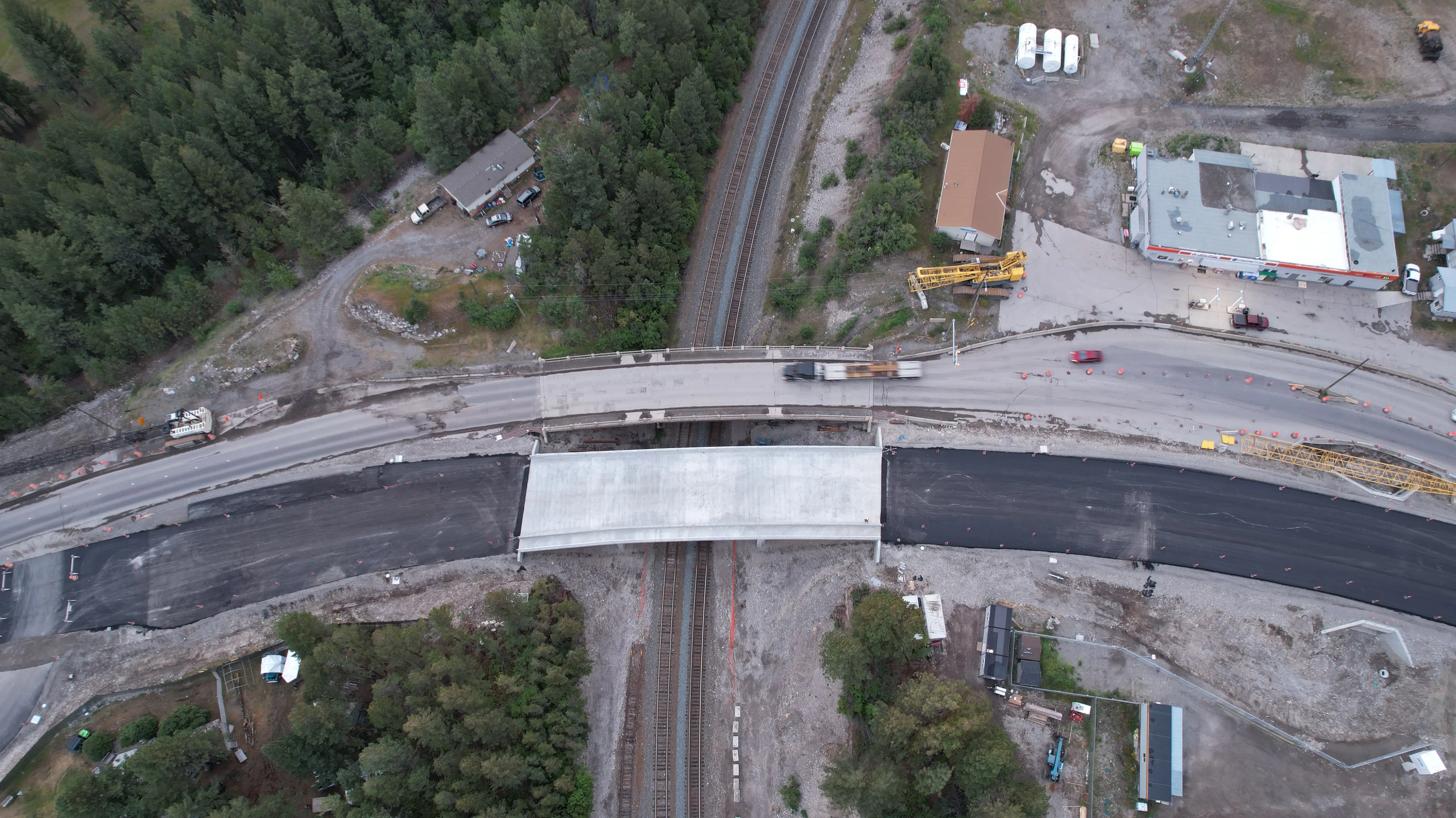 Aerial view of a new highway curve cut through forested mountain terrain