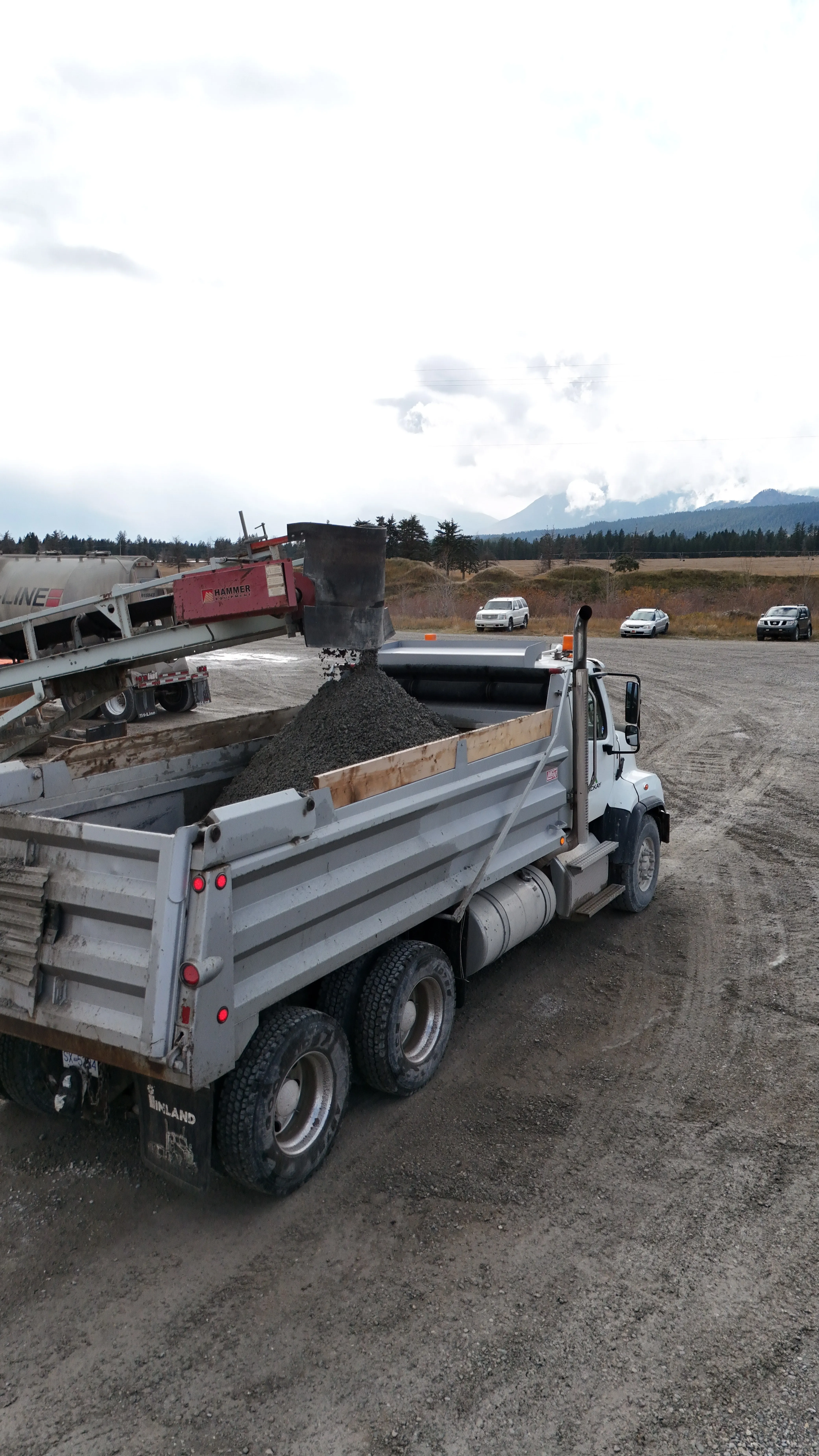 Crusher conveyor loading processed aggregate into a dump truck