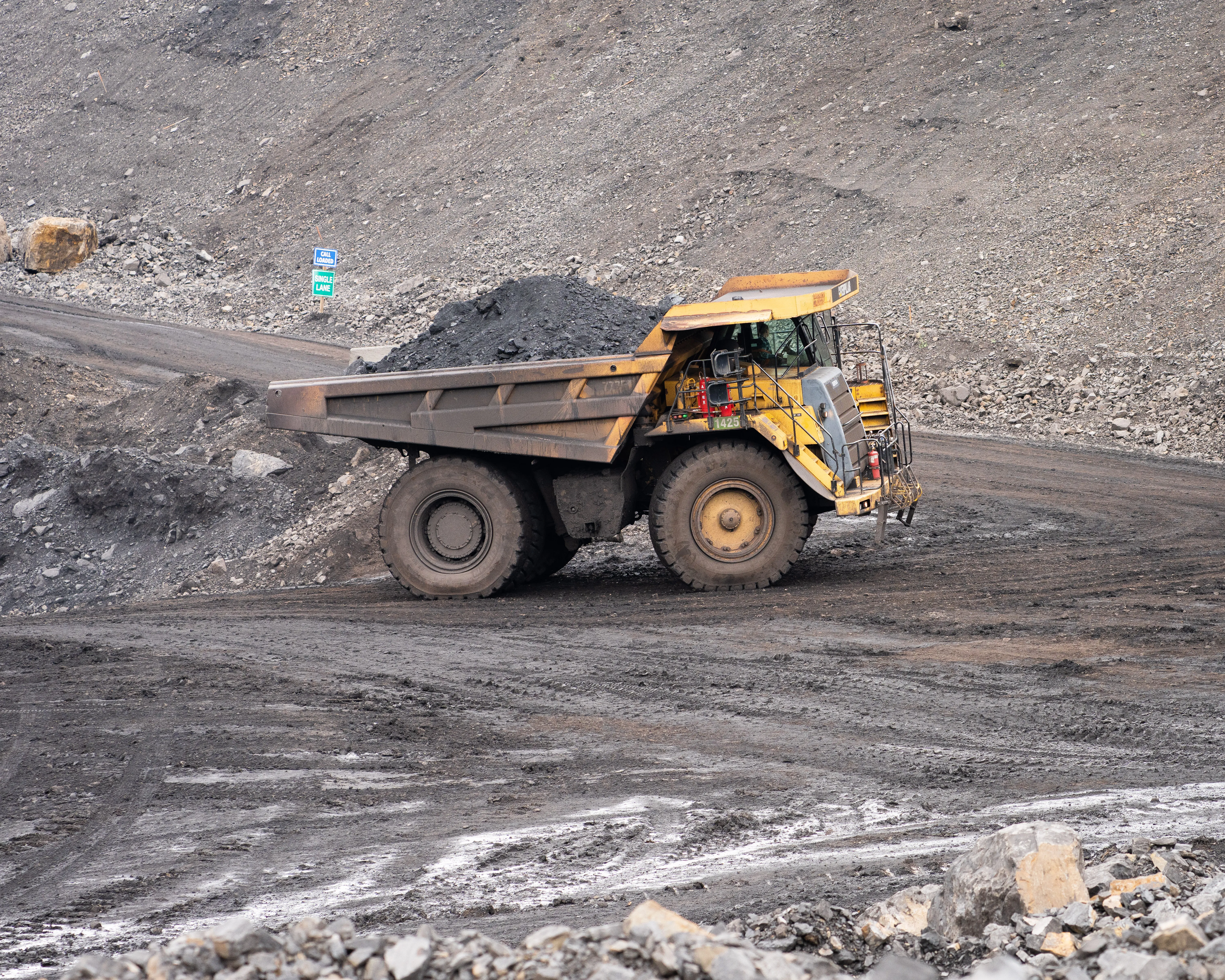 Excavator loading a haul truck under lights during night mining operations