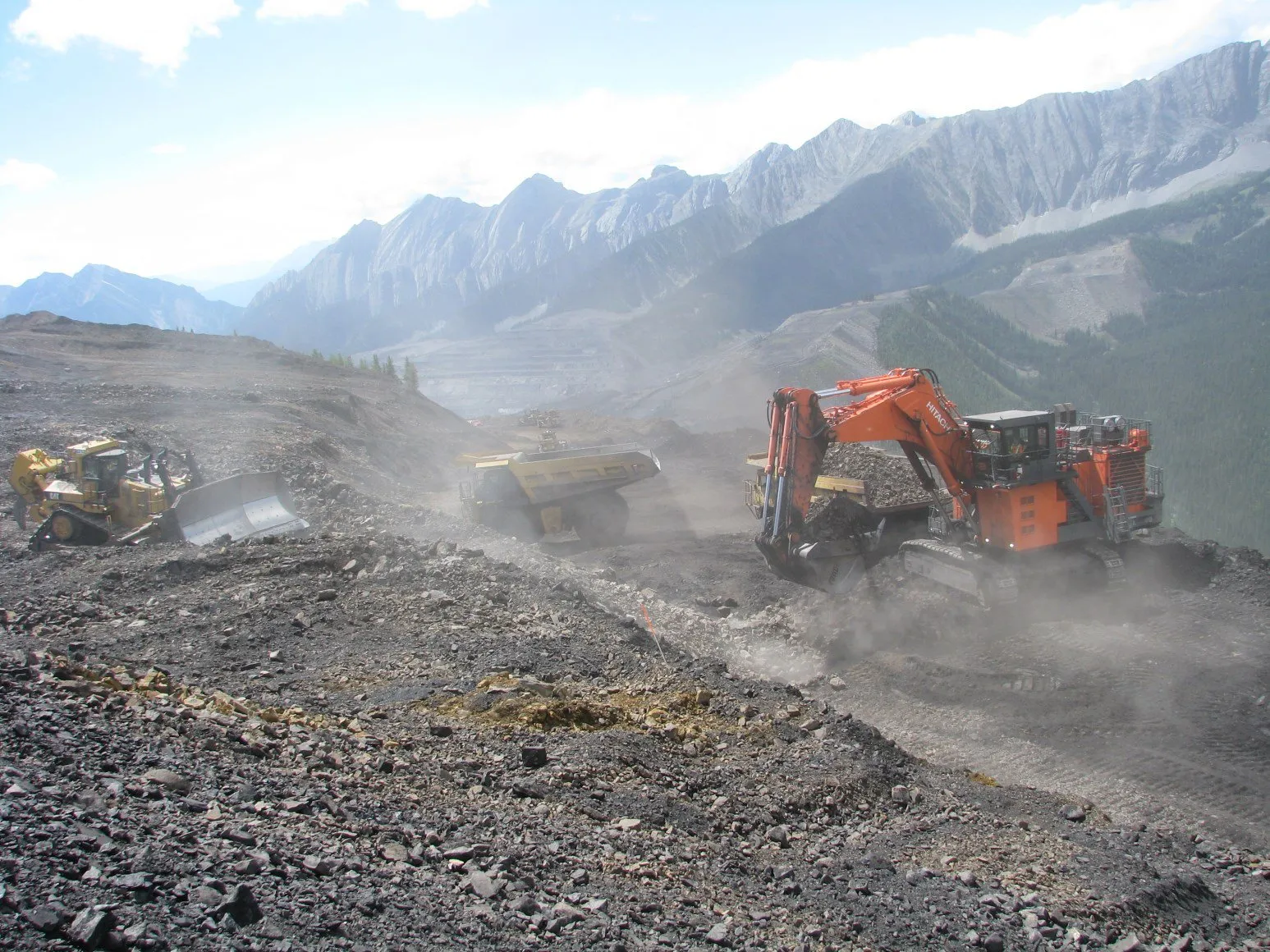 Excavators and dozer cutting the Mount Michael bench in dusty conditions