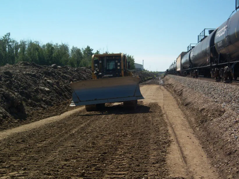 Grader working the new siding grade beside rail tank cars