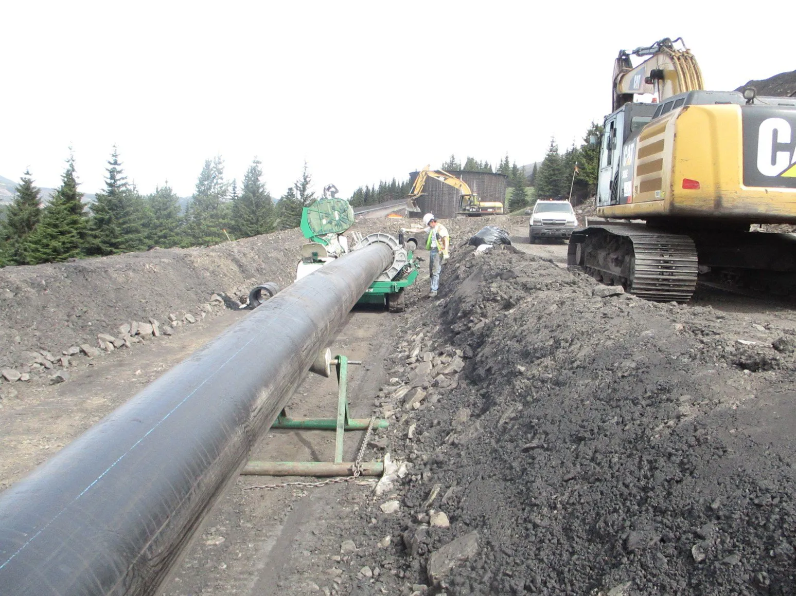 Crew and excavator laying HDPE tailings pipeline at Fording River