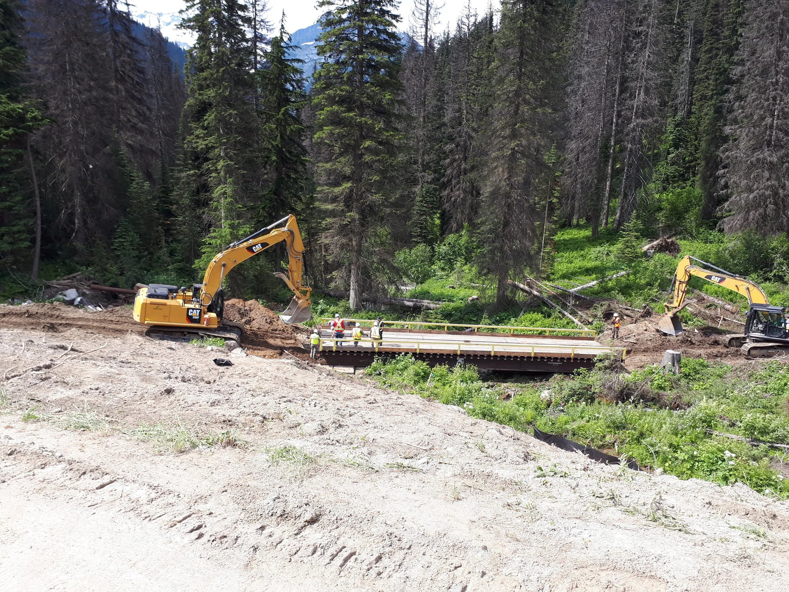 Crews building a creek crossing on a restoration site in the forest